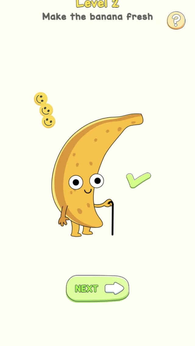 Delete Puzzle level 2 solved with the banana turned fresh and yellow, a green check mark, floating smileys, and a NEXT button