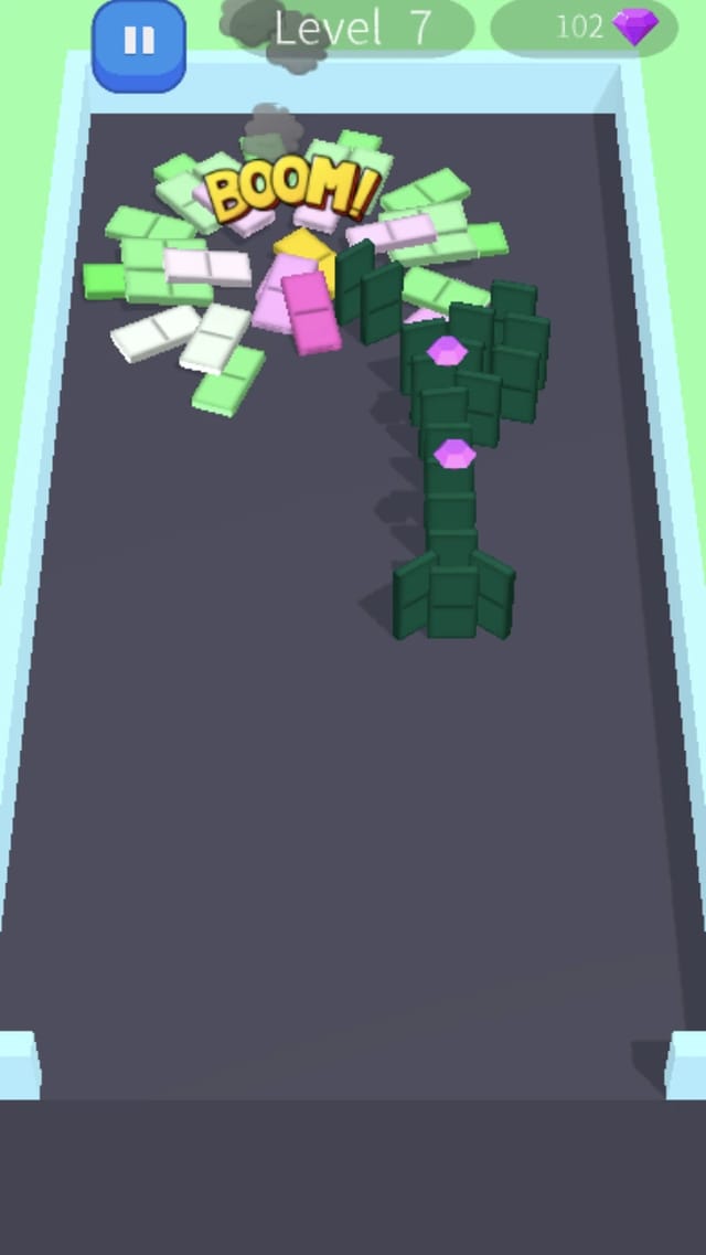Domino Frenzy level 7 mid chain reaction as a bomb detonates with BOOM text and smoke, toppling the flower-shaped dominoes