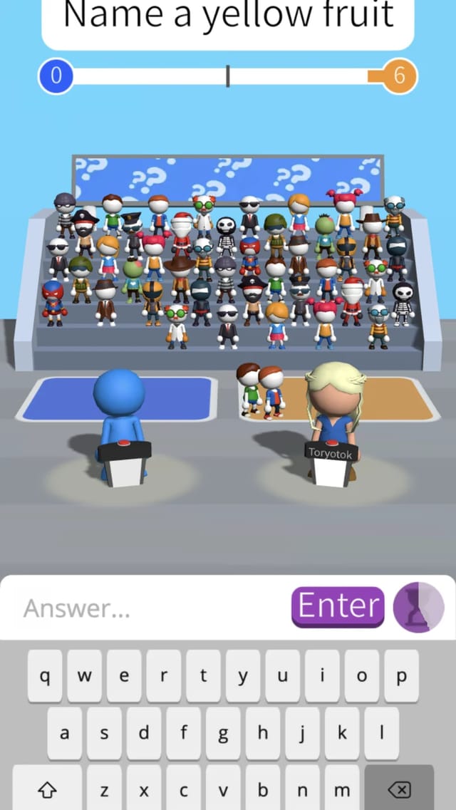 A Guess Their Answer round asking Name a yellow fruit, with the versus score bar at 0 to 6, the watching crowd, two podiums and the on-screen keyboard