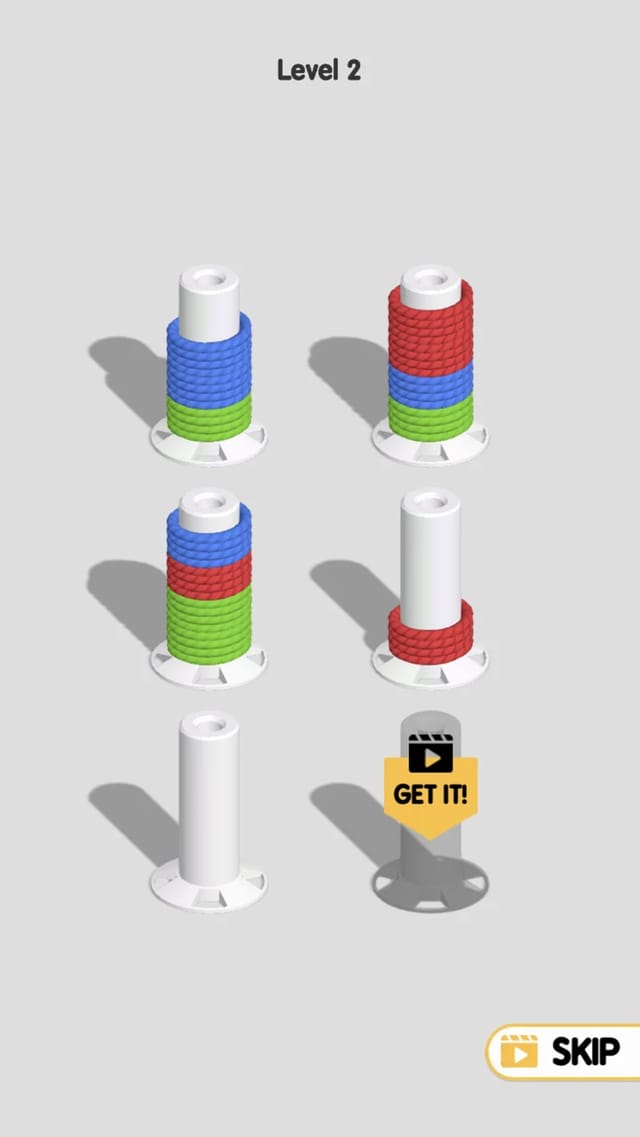 Rope Sort level 2 mid-puzzle showing five spools holding mixed red, blue and green rope coils, one red coil already set onto a previously empty spool and one spool still empty